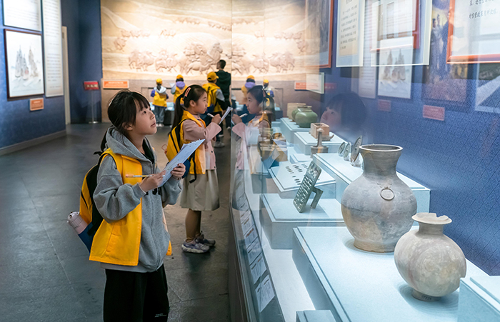 图为运城博物馆内，前来参观的小学生认真听着讲解。运城市委宣传部供图